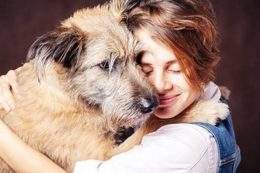 ペットの犬と抱き合う女性