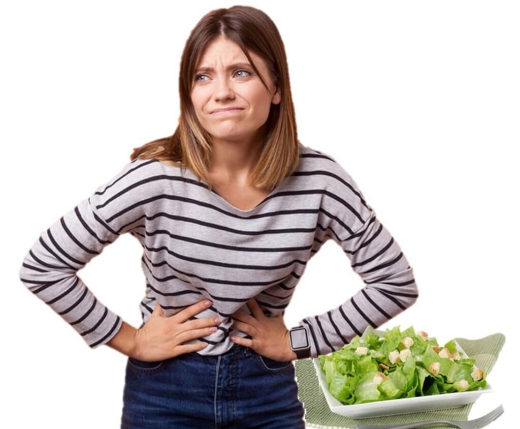 サラダを食べて腹痛を起こす若い女性